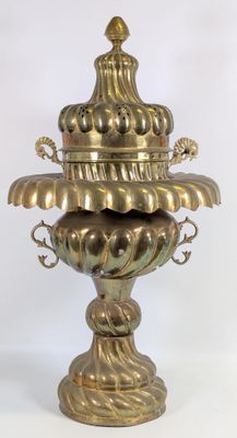 un vase en or posé sur une surface blanche