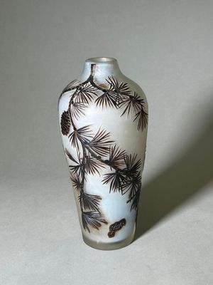 un vase blanc orné d'un motif représentant un pin