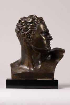 a bronze bust of a man with curly hair on a marble base
