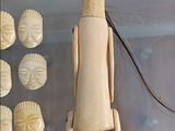 a wooden doll that is on display in a glass case