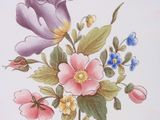 a plate with flowers and butterflies on it on a table