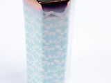 un vase bleu et blanc posé sur une surface blanche
