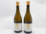 deux bouteilles de vin posées l'une à côté de l'autre sur une surface blanche