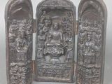 une petite statue représentant un homme et une femme devant une porte