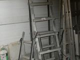 de nombreuses échelles appuyées contre le mur du garage