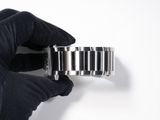a person holding a watch in their hand on a white surface