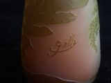 un vase orné d'une feuille, posé sur une table noire