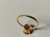 an image of a gold ring with an orange stone in the middle