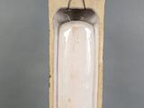 a white urinal with a black handle on a gray background