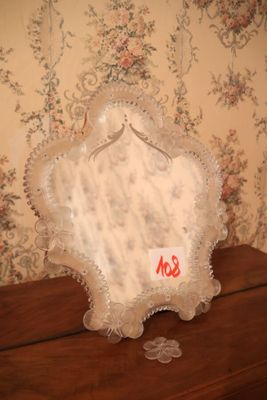 un petit miroir posé sur une commode en bois