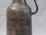 a brown vase with a handle on a white background