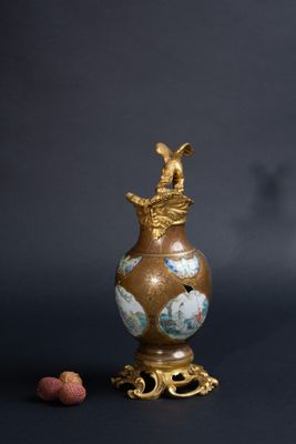 un vase ancien orné d'un oiseau, à côté d'un bouchon