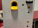 une boîte blanche munie d'une poignée jaune, posée sur une table rouge