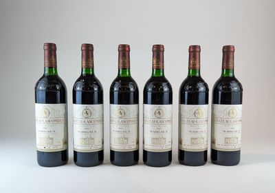 six bouteilles de vin sont alignées sur une surface blanche