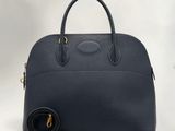 un sac à main en cuir noir avec des finitions dorées et une bandoulière
