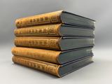 a stack of five old books sitting on top of each other