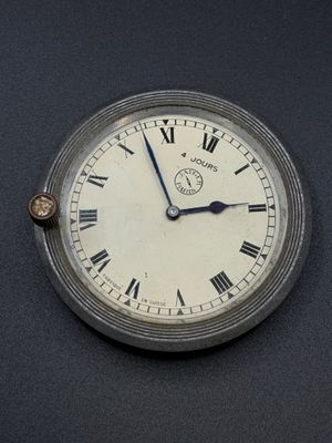a silver clock with roman numerals on the face