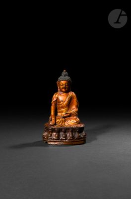 an image of a wooden statue of a person sitting on a rock