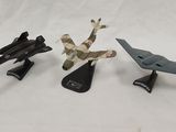 three toy airplanes that are sitting on a white surface