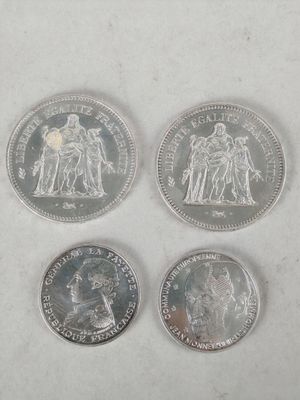 quatre pièces de monnaie britanniques différentes posées sur une surface blanche