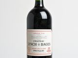 Une bouteille de vin rouge millésimé Château Lynch & Bages posée sur une table en bois