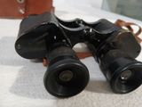 a pair of binoculars sitting on a table next to a bag