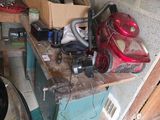 a pile of tools on a workbench in a garage