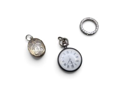 a small pocket watch and a ring on a white surface