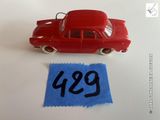 une petite voiture rouge et un bout de papier bleu posés sur une table