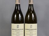 two bottles of wine sitting on top of a table next to each other