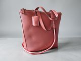 Le sac cabas en cuir rose est posé sur une surface blanche.