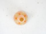 underside view of a pink and yellow glass vase on a white surface