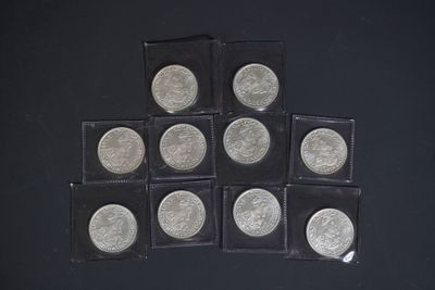 six pièces d'argent de 25 cents sont disposées en pyramide sur une surface noire