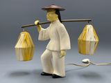 a figurine of a man holding a lantern and a stick