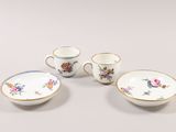 four pieces of porcelain dishes and cups on a white surface