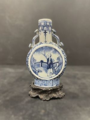 a blue and white vase with a bird on it