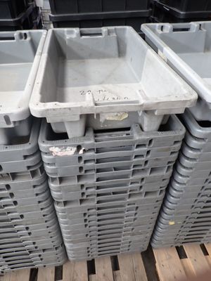 de nombreux conteneurs en plastique empilés les uns sur les autres sur une palette