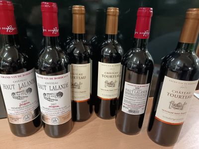 plusieurs bouteilles de vin rouge sont alignées sur une table