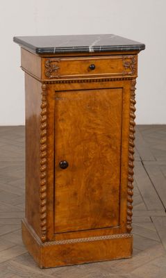 une vieille armoire en bois avec un plateau en marbre, posée sur un parquet