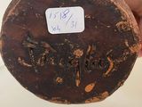 a person holding a piece of pottery with writing on it