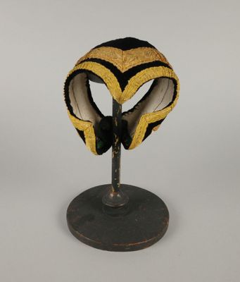 masque jaune et noir posé sur un support, sur fond blanc