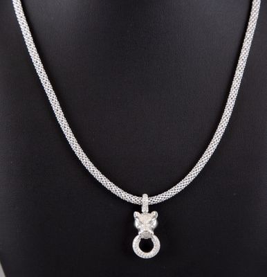 a white gold necklace with a diamond pendant on a mannequin