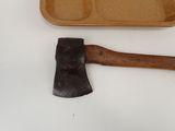 an old axe next to a tray of food on a table