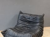 black leather chair and ottoman in front of a gray wall