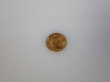 a close up of a gold coin on a white surface