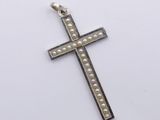 a silver cross with pearls on a white background