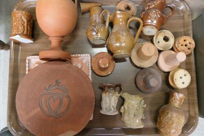 un plateau sur lequel sont disposées de nombreuses pièces de poterie de styles variés