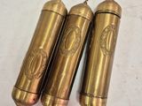 three antique brass fire extinguisors on a white surface