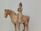 une statue représentant une femme à cheval, posée sur une table transparente