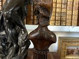 bronze statue of a woman holding a vase on a wooden base